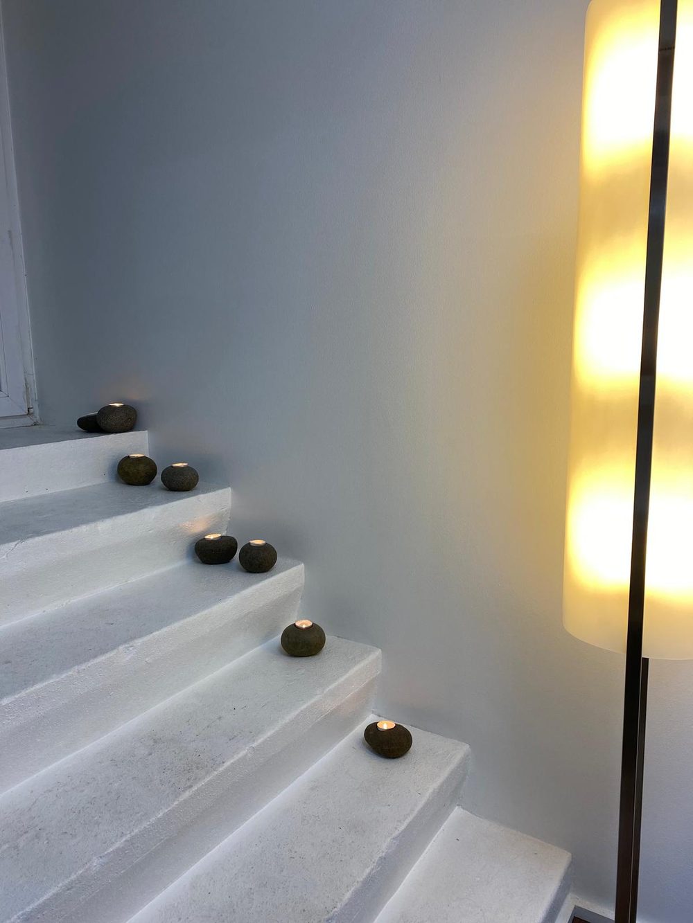 White staircase with stone candle holders